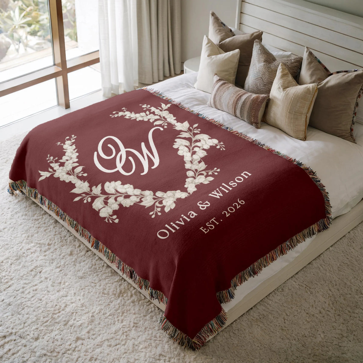 Personalized burgundy monogram wedding woven blanket styled on a neutral bed
