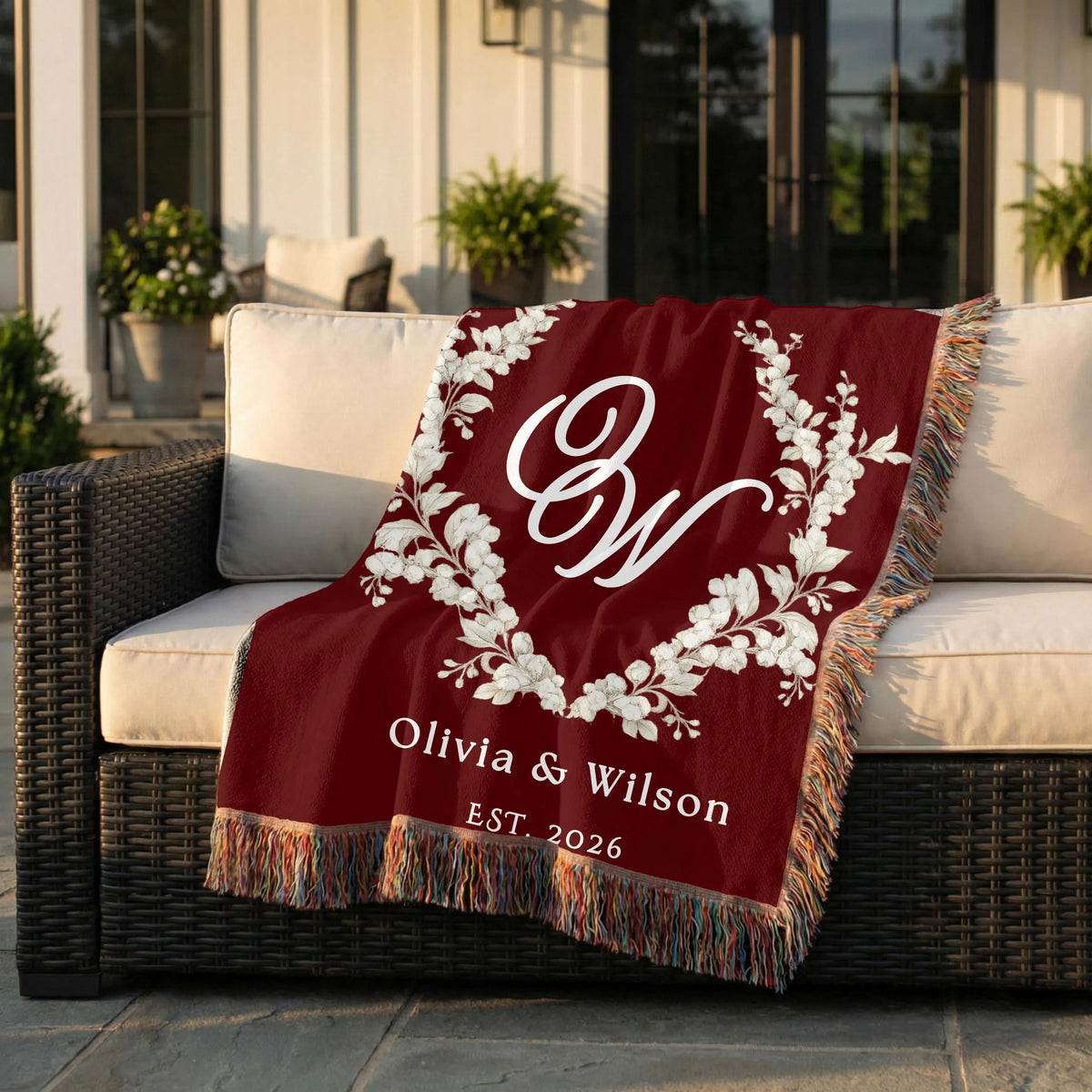 Personalized burgundy couple woven blanket displayed on an outdoor chair
