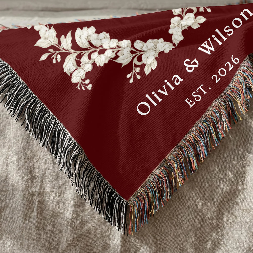 Close up of burgundy personalized woven blanket with decorative fringe